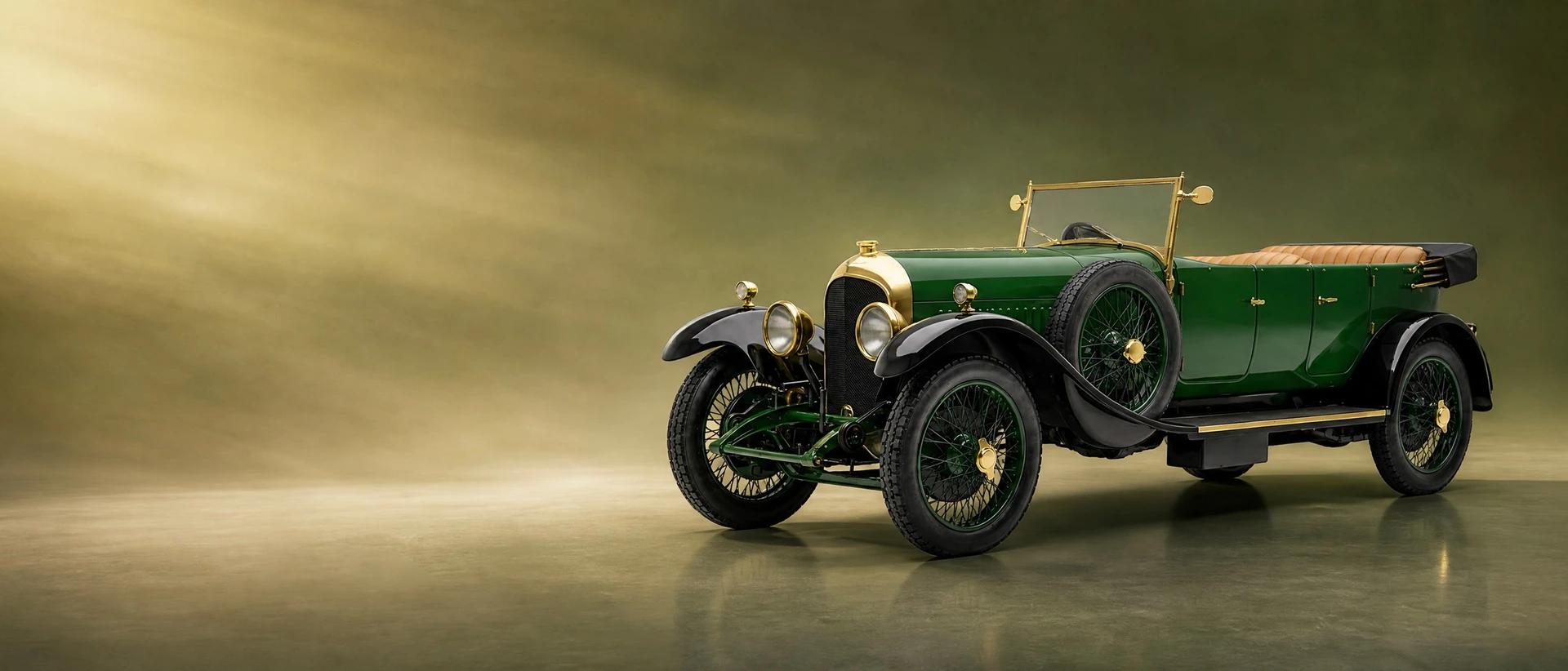 A green Bentley 3 Litre with brass fittings, front three-quarter view on an olive field with warm morning light