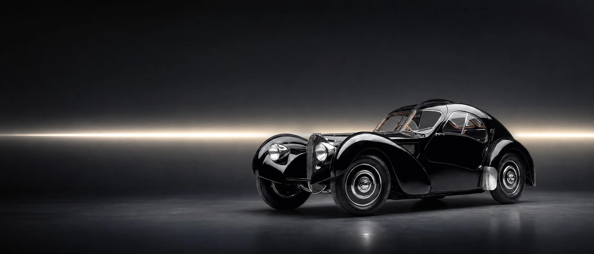 A black Bugatti Type 57 SC Atlantic, front three-quarter view on a graphite field with a pearl seam of light