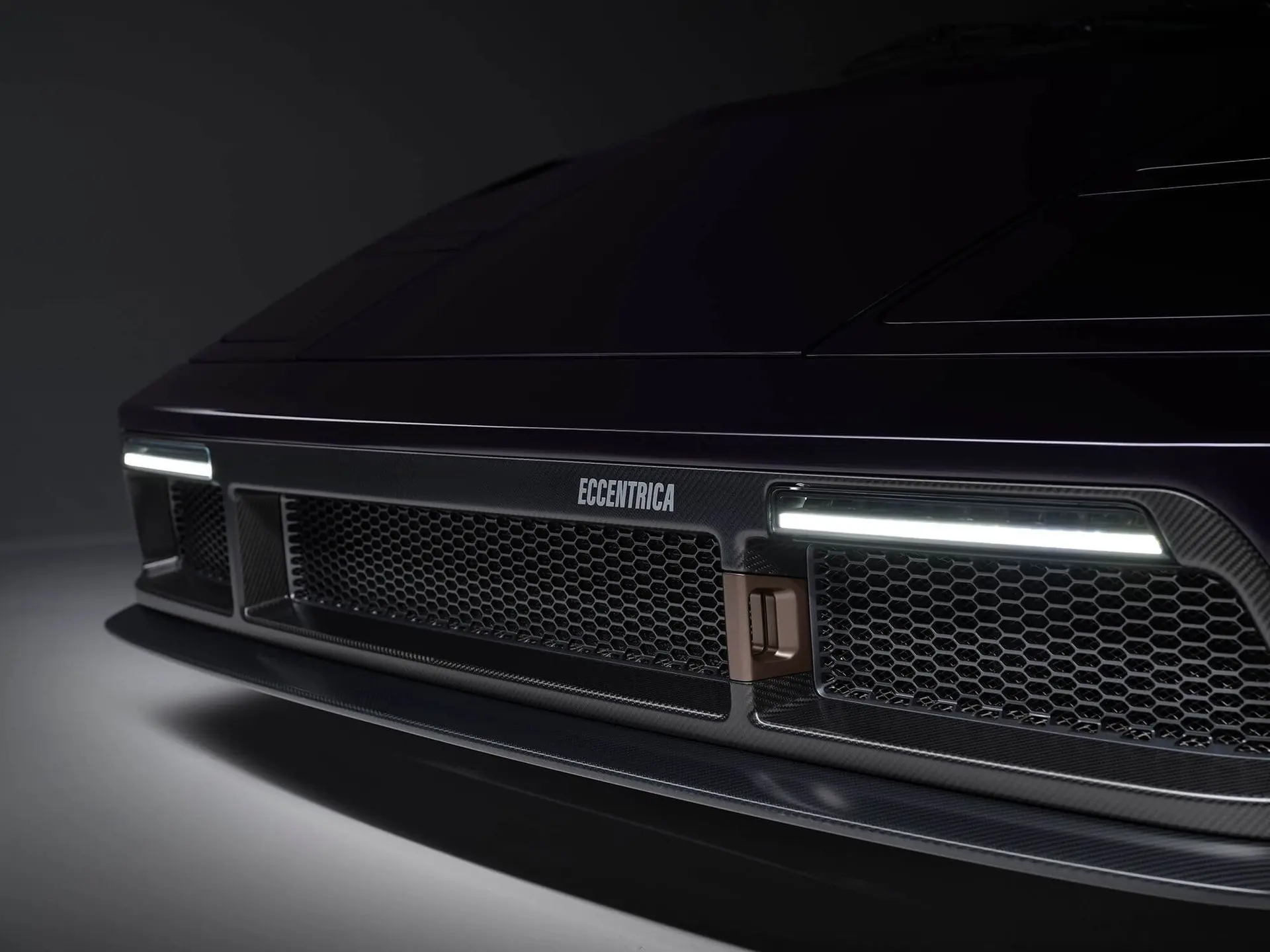 Eccentrica V12 front fascia in dark violet with carbon splitter and slim LED running lights