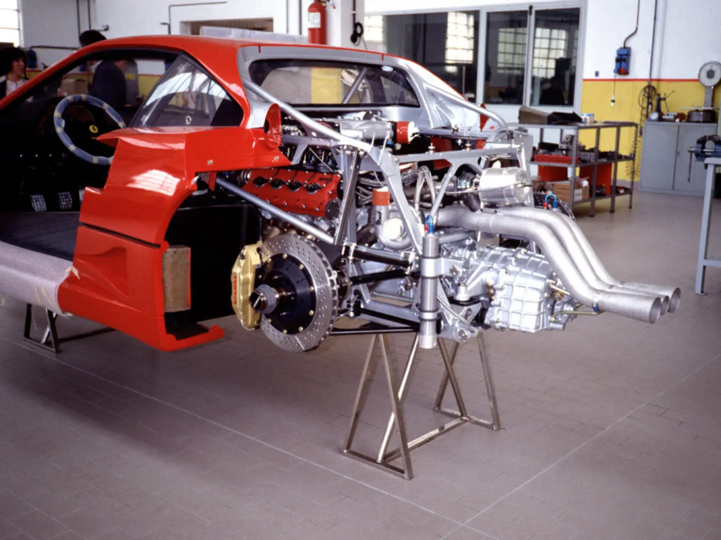 An F40 with its twin-turbo V8 and chassis exposed in the workshop
