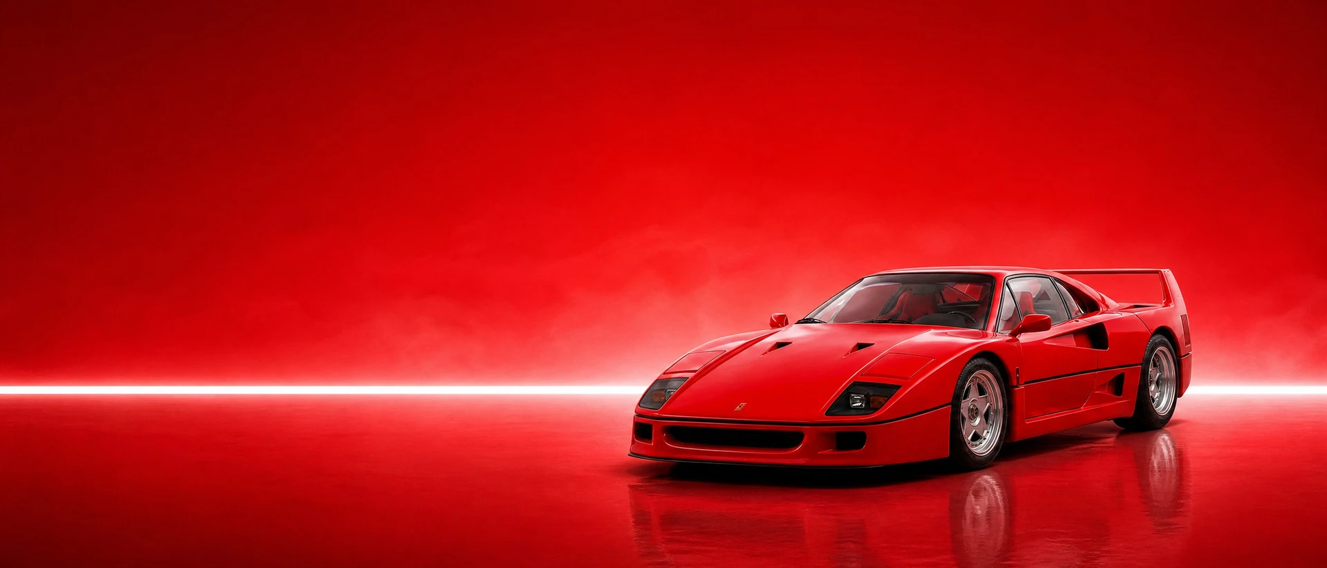 A red Ferrari F40, front three-quarter view on a rosso field with a hard bar of light
