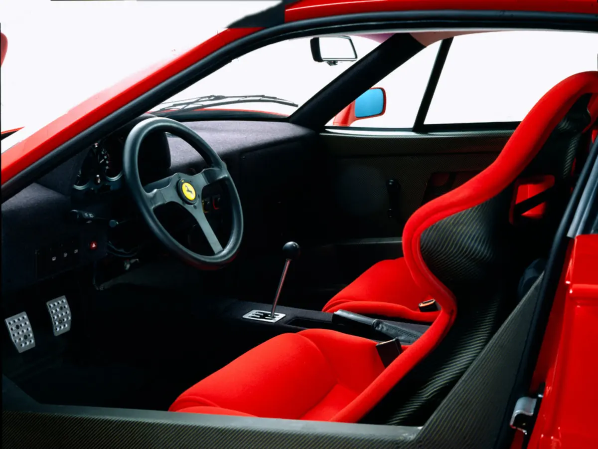 F40 cockpit: red cloth seats, open-gate shifter, exposed pedals