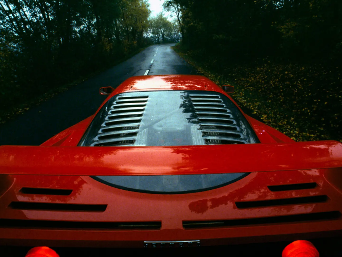 The F40 from behind on a wet road, louvred engine cover and rear wing