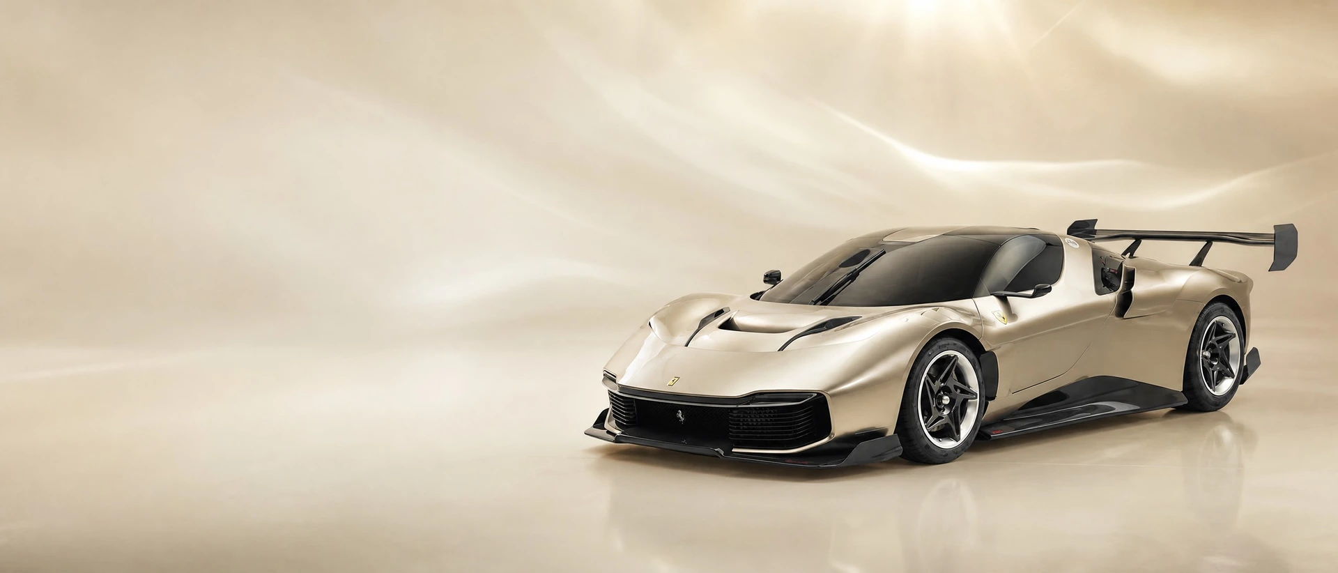A gold metallic Ferrari KC23, front three-quarter view on a white field with soft gold light