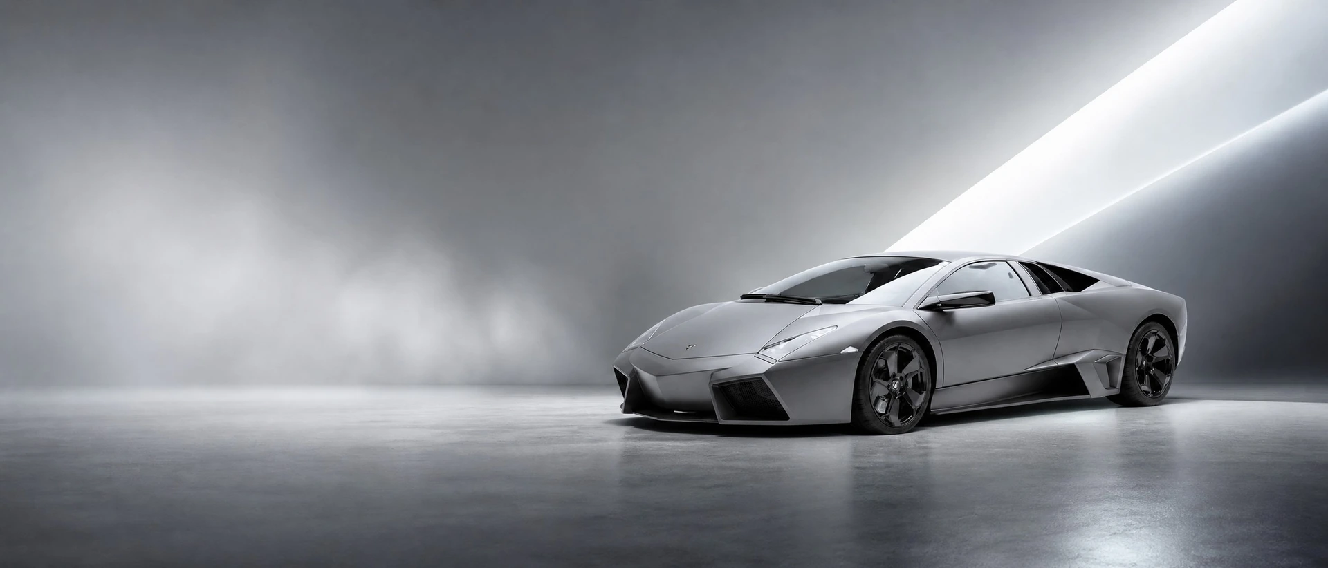 A matte grey Lamborghini Reventon, front three-quarter view on a matte grey field with a shard of light