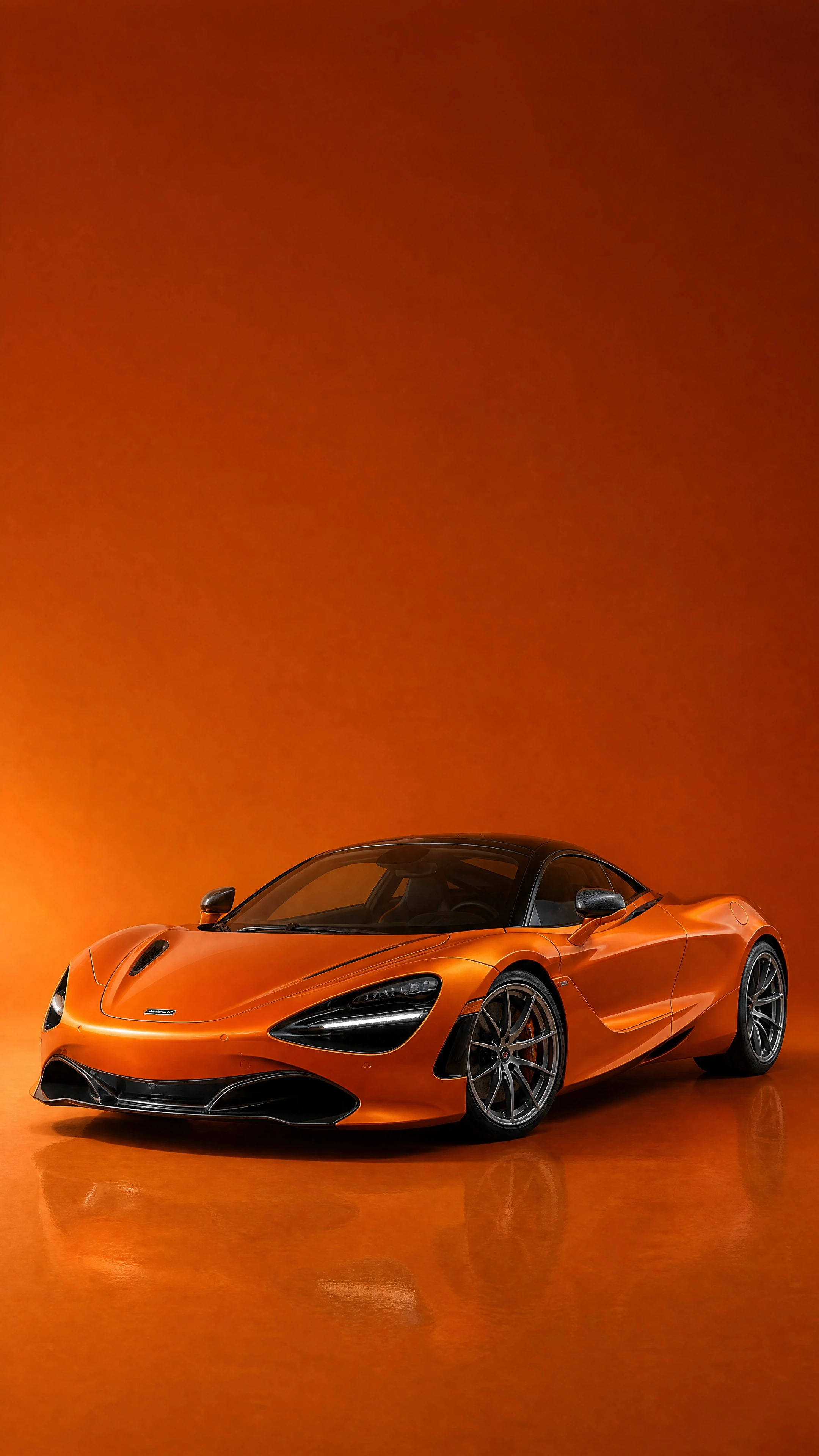A McLaren Orange 720S, front three-quarter view on a deep burnt-orange field in warm daylight