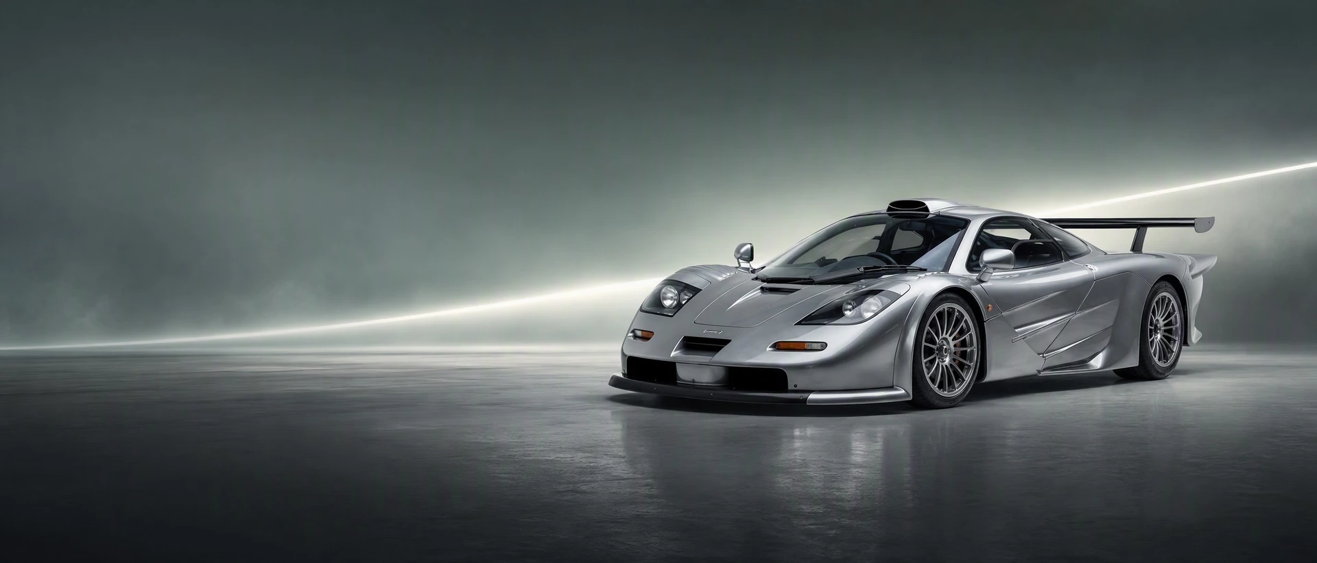 A McLaren F1 GT Longtail, front three-quarter view on a field with a longtail light streak