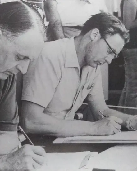 John Horsman, pen over the timing sheets, with John Wyer at the Le Mans pit counter, 1968