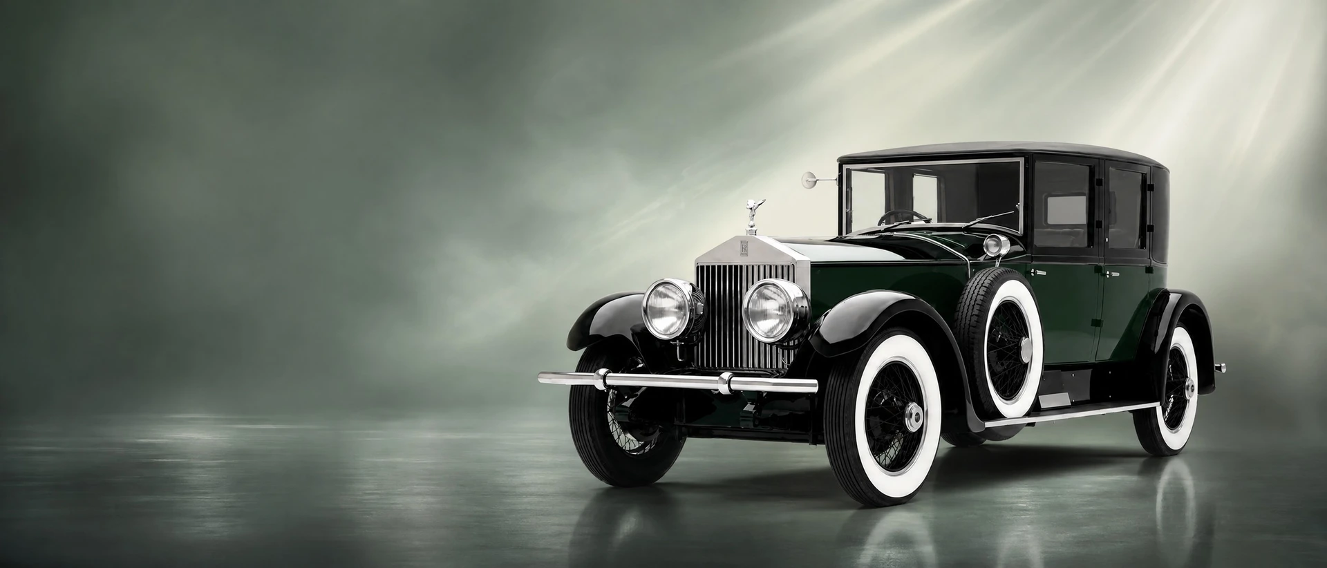 A dark green Rolls-Royce Phantom I, front three-quarter view on a silver-green misty field
