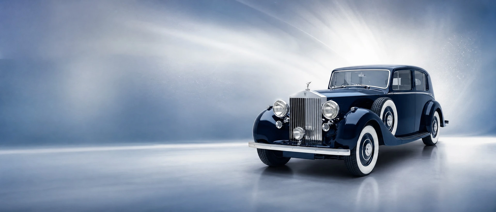 A deep blue Rolls-Royce Phantom III, front three-quarter view on a silver-blue field with pearl light