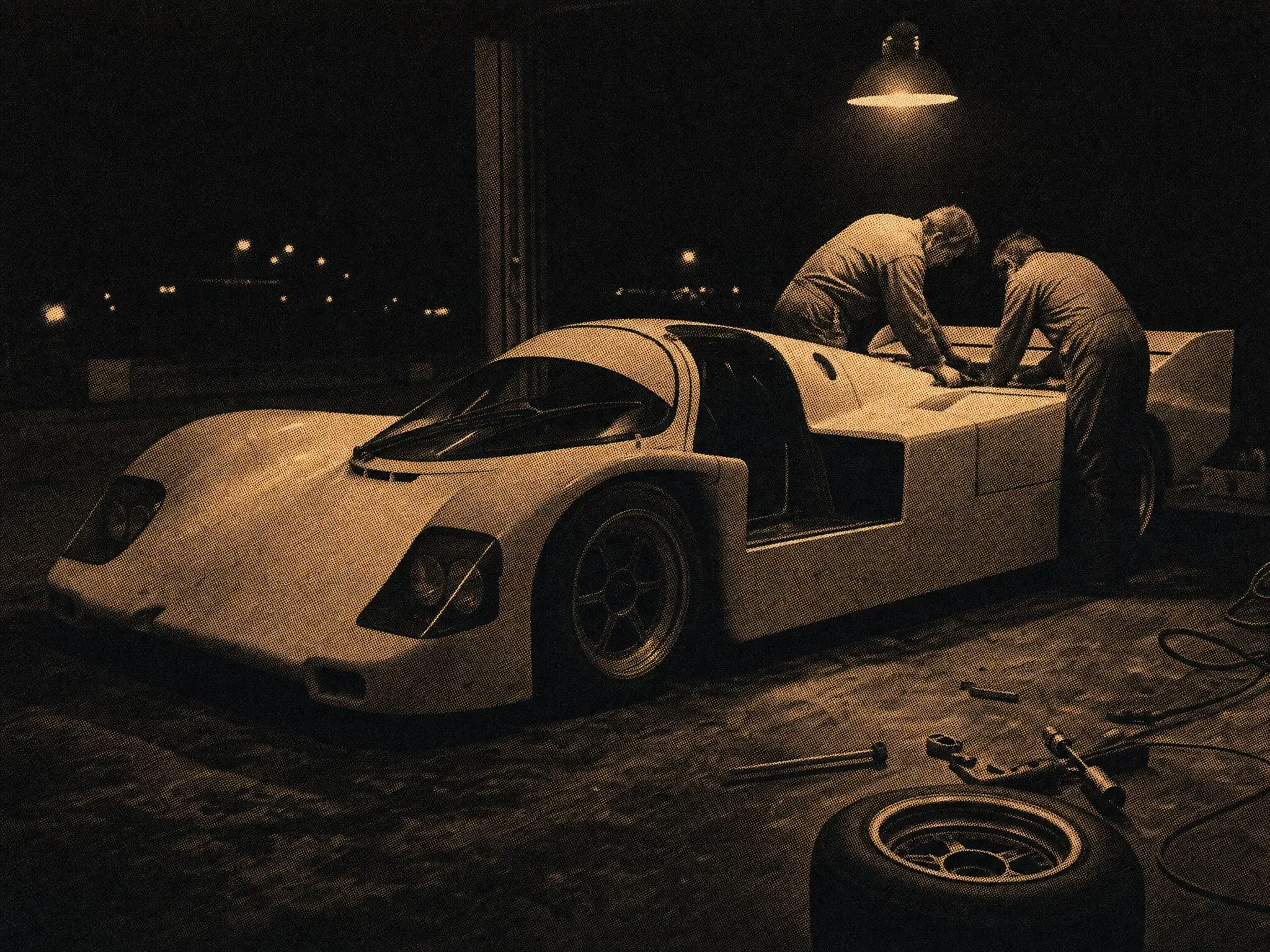 Art plate: a Porsche 956 in an open pit garage at night, left door missing, two mechanics under one work lamp